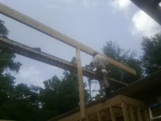 Carpenter setting a ridge beam over a new addition frame — Ice Dam Removal by Roofing Brothers in Elbe