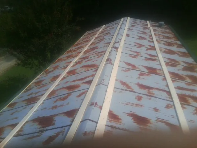 Rusted metal roof panels with new wood purlins before replacement — Storm Damage Roof Repair in Elbe by Roofing Brothers