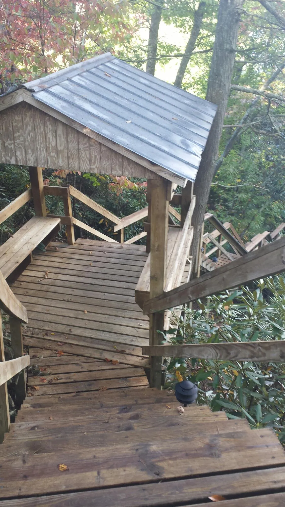 Metal roofed shelter over wooden steps on a wooded walkway — Skylight Repair & Installation work by our crew in Elbe